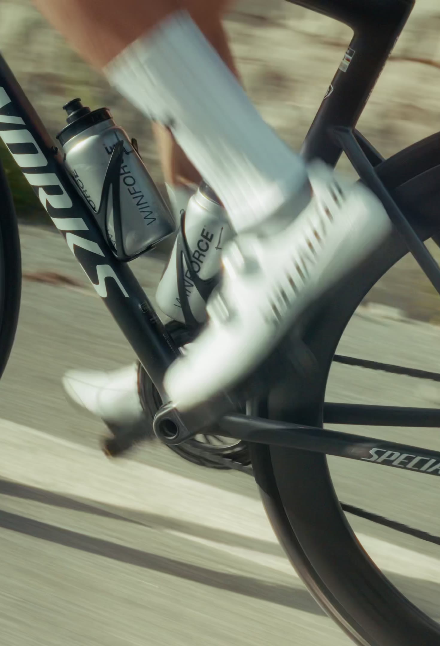 Cranks and wheels of an S-Works road bike at speed, the road behind blurred by the motion.